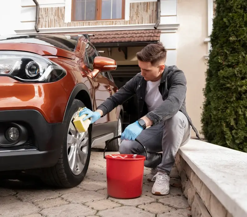 Lavage auto à domicile Oulchy-le-Château : professionnel intervenant sur un véhicule